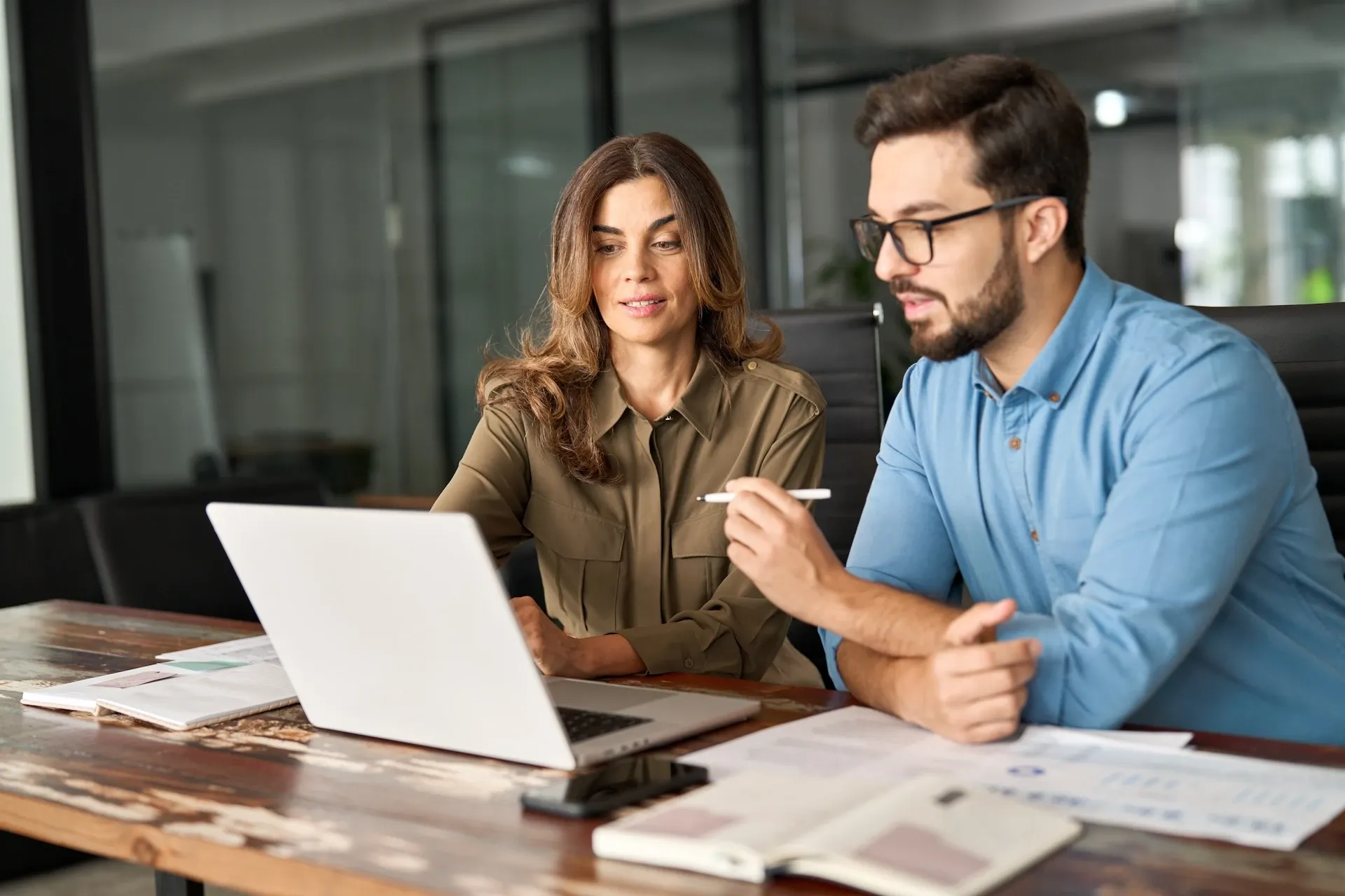 Colleagues reviewing work on a laptop